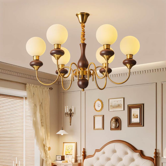 "Gold and dark wood Eurot chandelier with frosted glass globes hanging in a traditional bedroom above a bed."