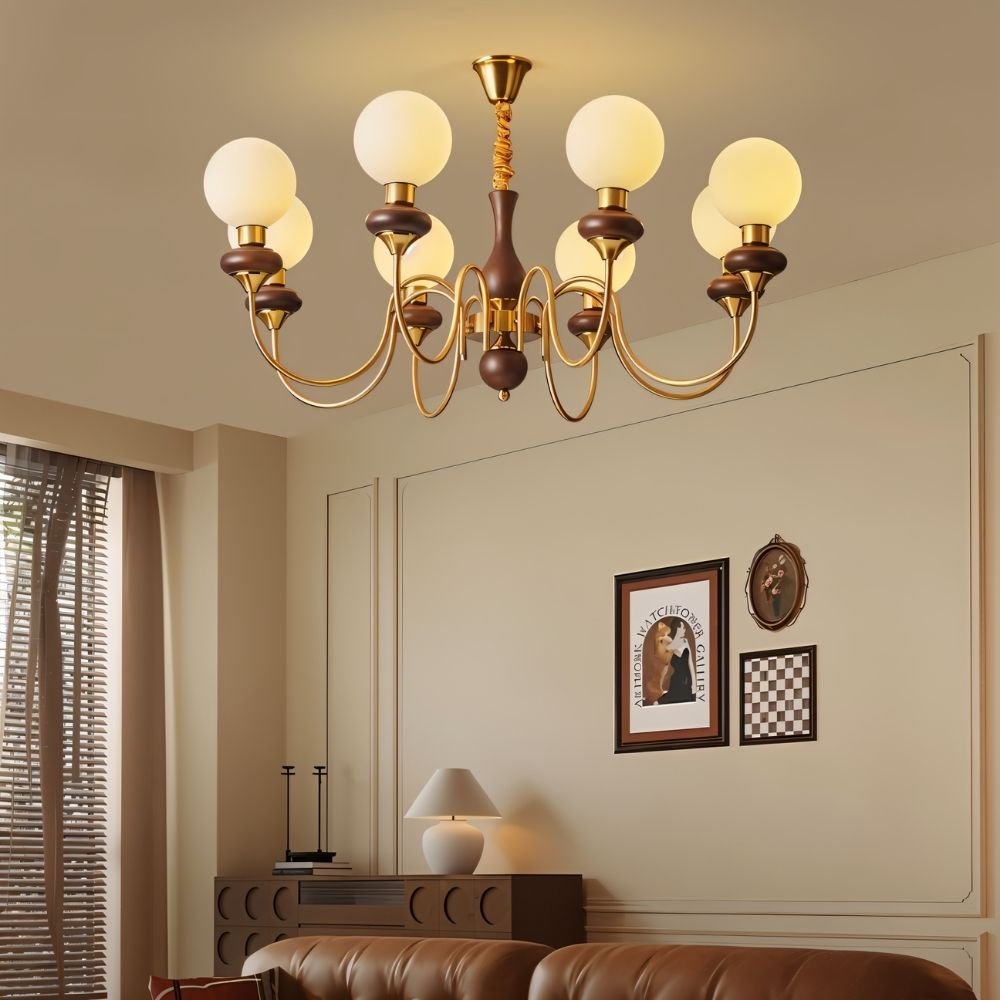 "Gold and dark wood Eurot chandelier with frosted glass globes hanging in a traditional living room with artwork on the wall."
