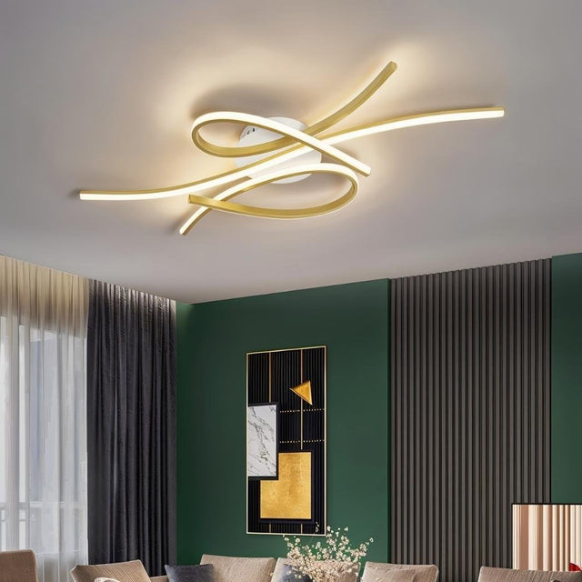 "A modern ceiling light with intertwining LED bars installed in a contemporary living room with a green accent wall."