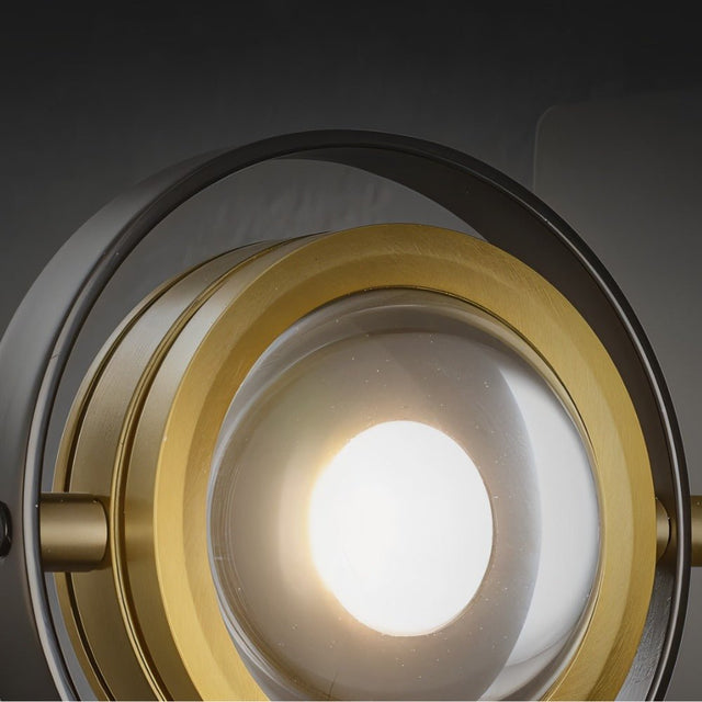 "A close-up view of the Fabli wall lamp showing the glass lens, brass ring, and lit bulb."