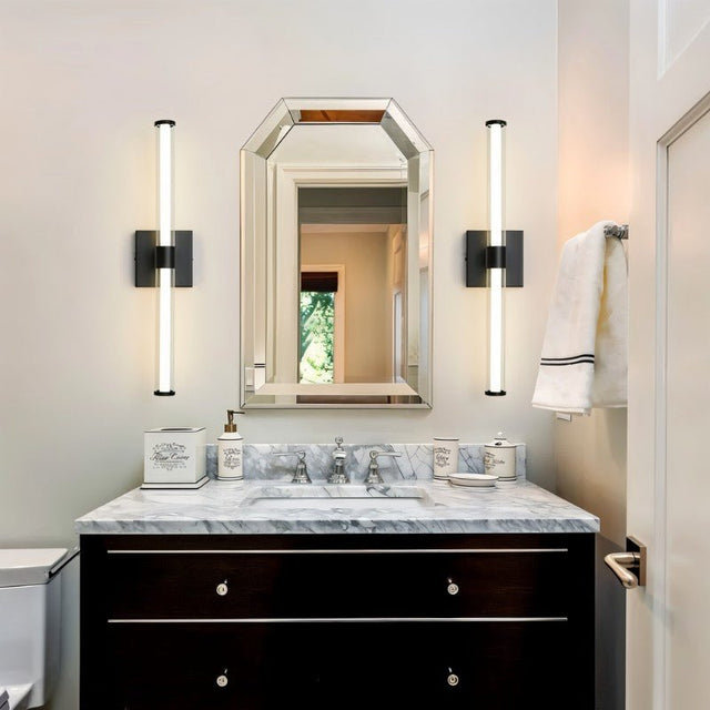 "Modern black wall sconces with clear glass shades flanking a bathroom vanity mirror."