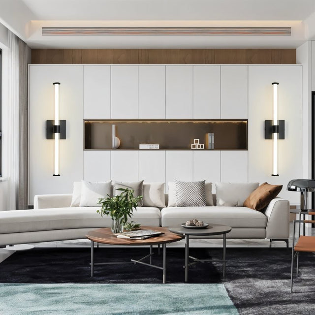 "Modern black wall lamps with clear glass shades flanking a decorative wall feature in a living room."