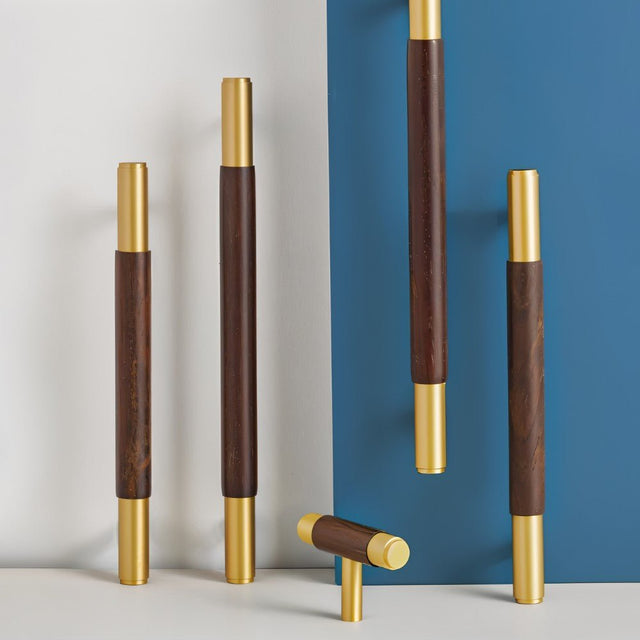 "Set of wood and brass knobs and pull bars with cylindrical design on a split blue and white background."