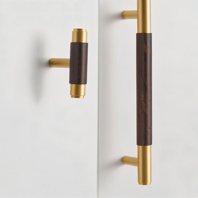 "Wood and brass knob and pull bar with cylindrical design on a white door."
