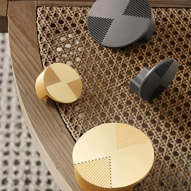 "Close-up of geometric cabinet knobs with etched detailing on cane furniture, showcasing a blend of modern and natural aesthetics."