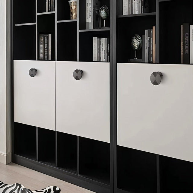 "Dark geometric knobs with etched detailing on a modern, black and white bookcase."