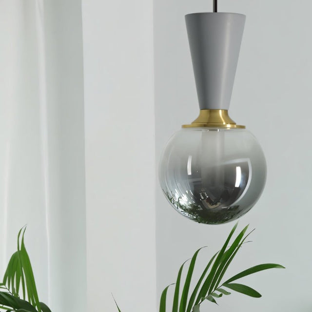 "Modern pendant light with a concrete cone-shaped top, metal accent, and smoky glass orb, showcasing a blend of industrial and sophisticated design."