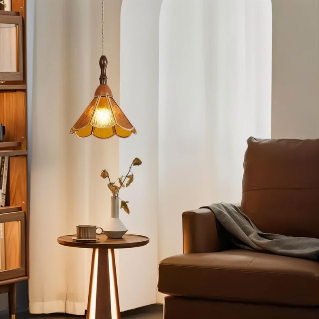 "Handcrafted amber glass pendant light with copper trim in a living room, illuminating a cozy seating area."