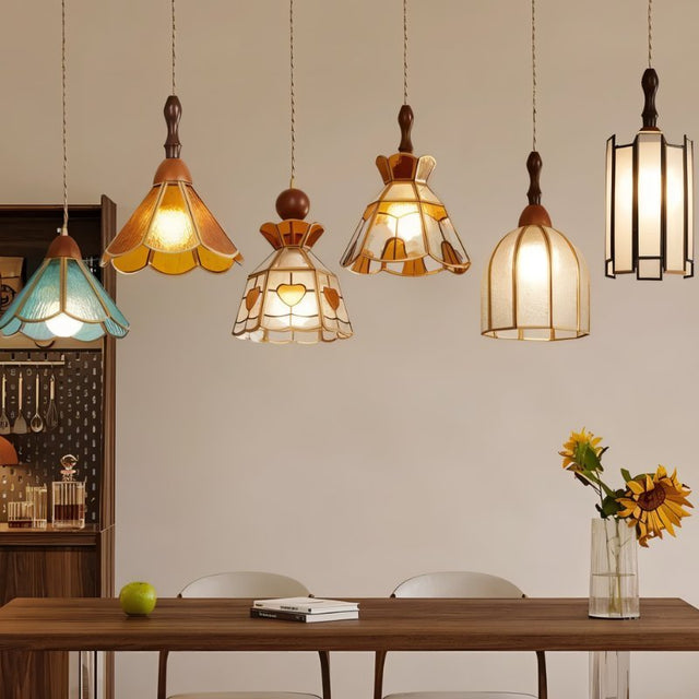 "Collection of handcrafted pendant lights with various stained glass designs and copper frameworks, showcasing different styles and patterns."