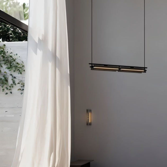 "Modern linear pendant light hanging near a window with sheer curtains, showing a minimalist interior."