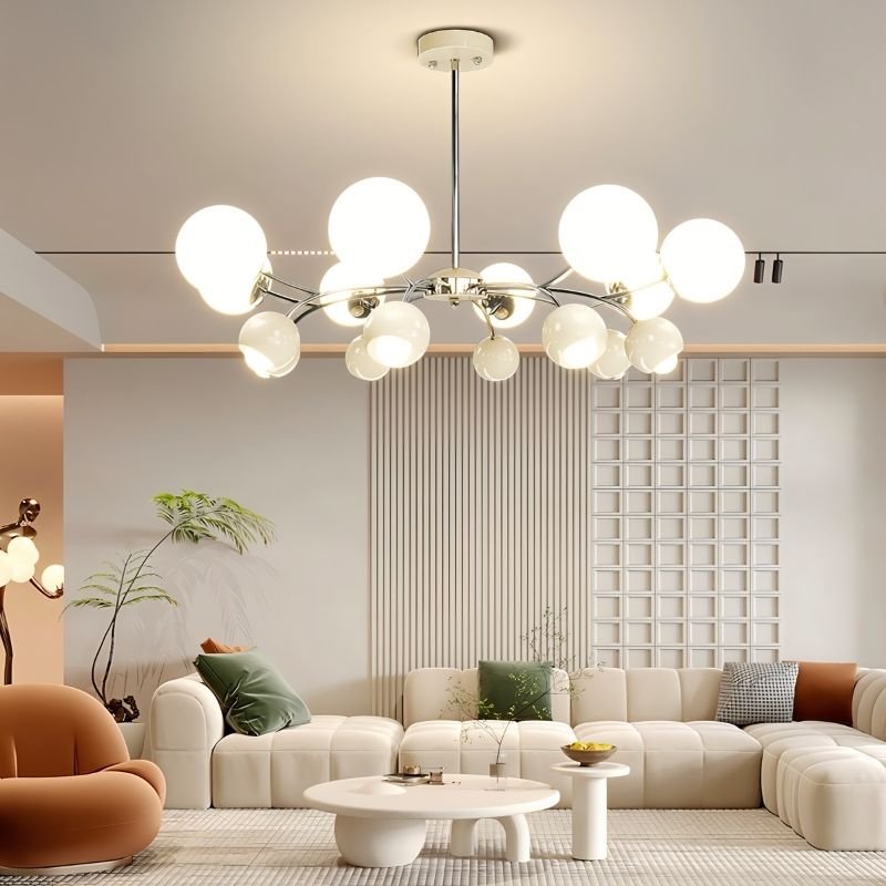 "A multi-light mid-century modern chandelier with acrylic globe diffusers, hanging in a modern living room with a white couch and decor."