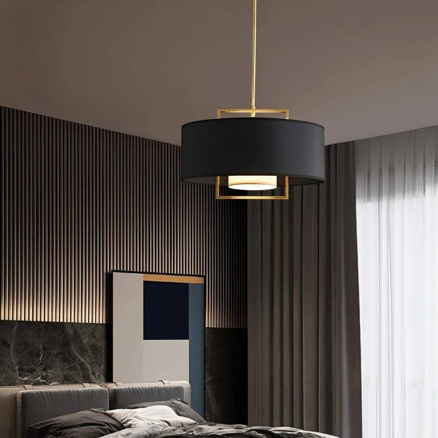 "A black pendant light with a gold frame in a bedroom setting."