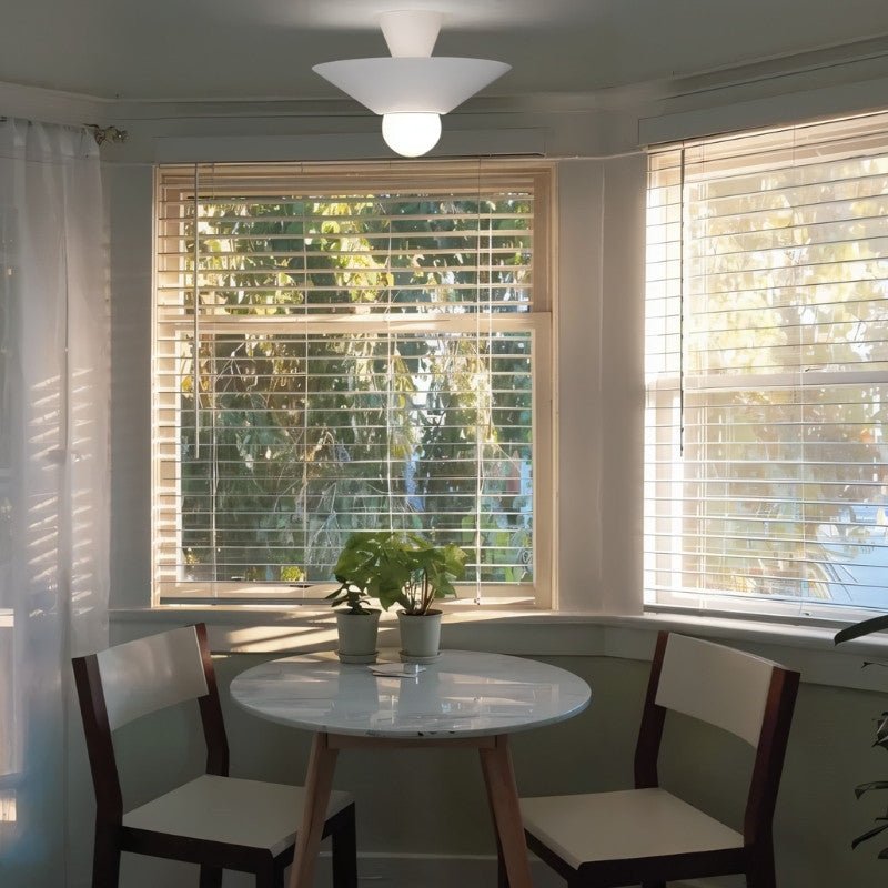 "The Glome Ceiling Lamp, with its modern design made of aluminum, installed in a cozy dining area, illuminating the space with ambient light while serving as a chic focal point."