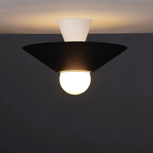 "The Glome Ceiling Lamp in black and white combination, emphasizing its artistic geometric design with a central globe bulb, installed in a dark-themed room for modern elegance."