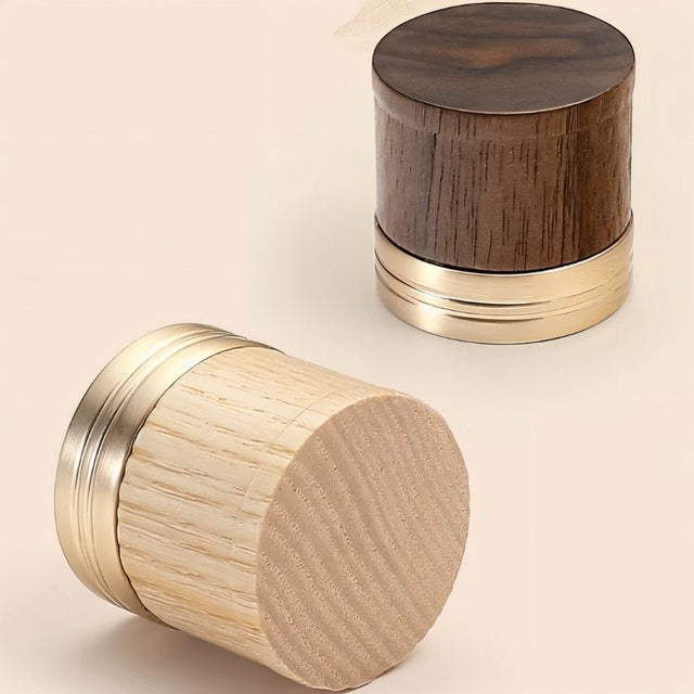 "Close-up of two modern knobs, each featuring a different wood tone paired with a golden metallic base."