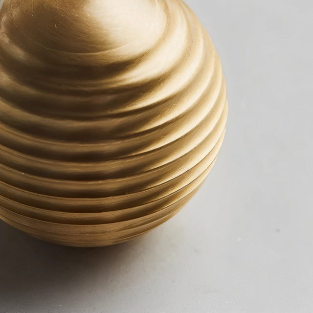 "Close-up of a gold brass ribbed knob showing the textured surface."