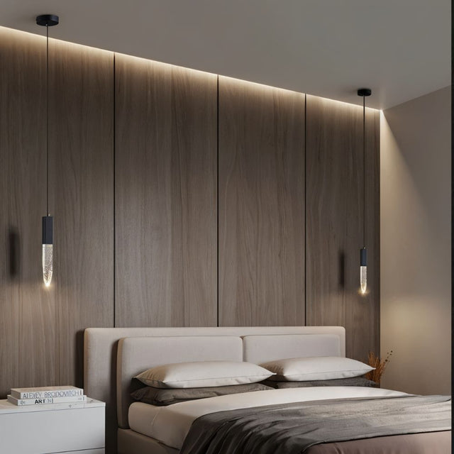 "Pair of modern pendant lights with crystal diffusers and metal frames in a bedroom with wood paneling."