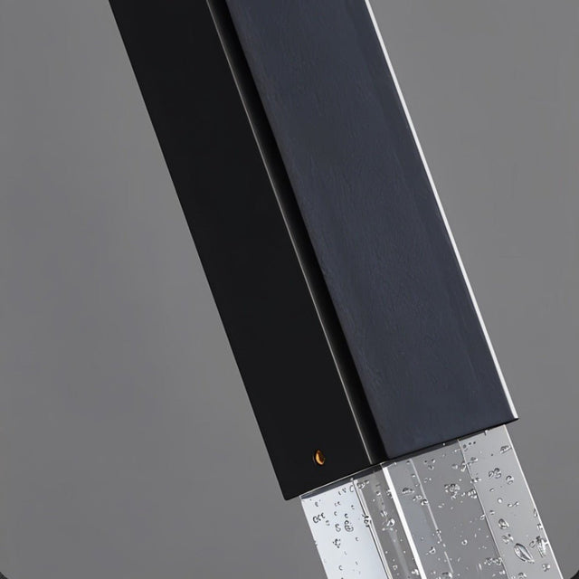 "Close-up detail of a modern pendant light showing a metal frame and textured crystal diffuser."