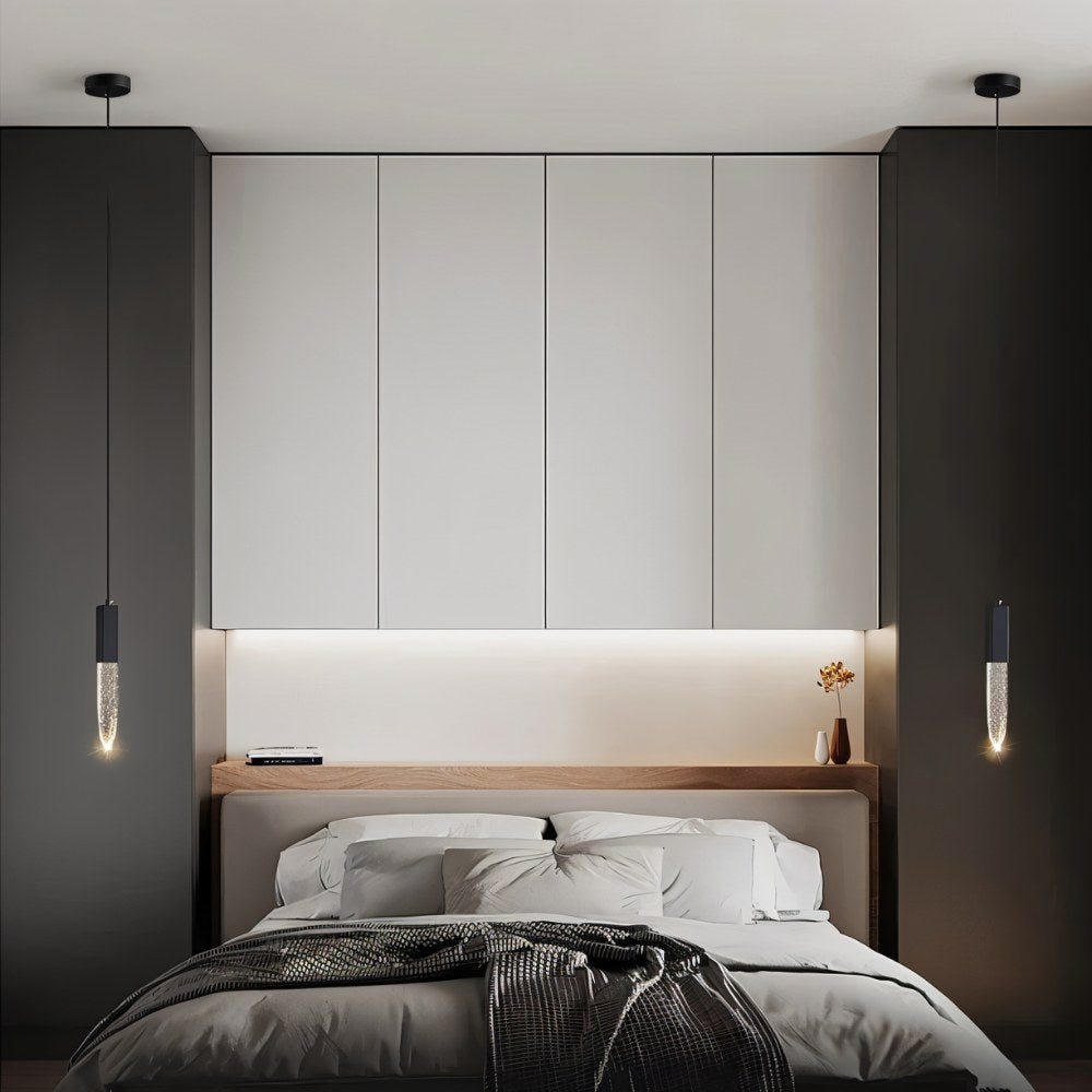 "Pair of modern pendant lights with crystal diffusers flanking a bed in a contemporary bedroom with built-in storage."