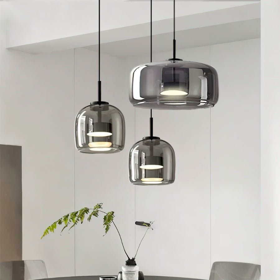 "Modern pendant lights with smoked glass dome shades hanging in a dining room."