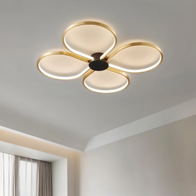 "Close-up of a modern ceiling light with four circular LED rings in a clover-like formation, showcasing its design."
