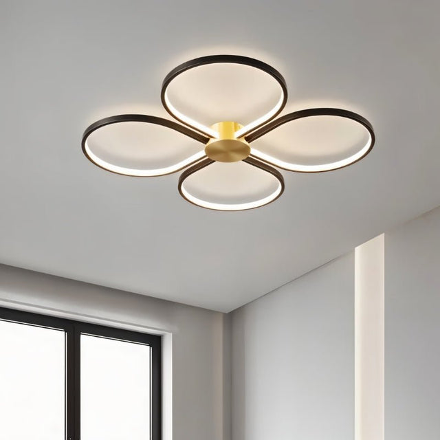 "Modern ceiling light with four circular LED rings in a clover-like formation, illuminating a contemporary room."
