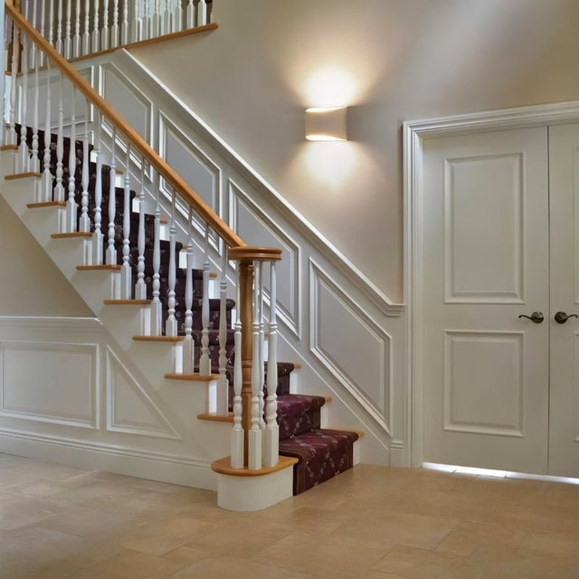 "Modern curved rectangular gypsum wall lamp providing soft ambient lighting for a contemporary staircase."