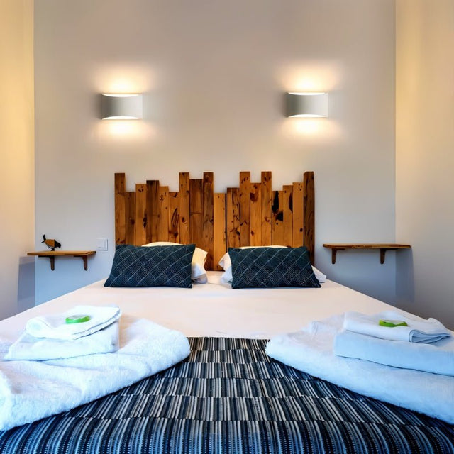 "Pair of modern curved rectangular gypsum wall lamps flanking a rustic wooden headboard in a contemporary bedroom, casting soft ambient light."