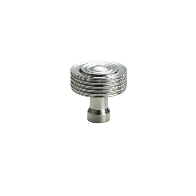 "A nickel-finished brass knob with a concentric ring design and ridged surface, suitable for modern and transitional interiors."
