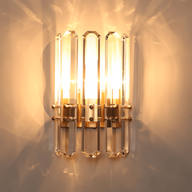 Lenvo Crystal Copper Wall Light illuminated in a dim room, casting radiant reflections through its crystal panels.