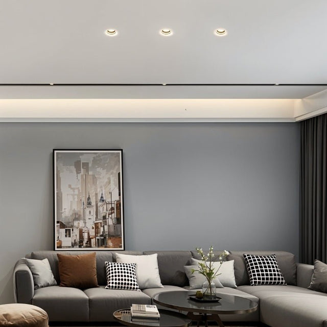 "Living room with multiple Loux Trimless Downlights providing seamless, minimalist illumination, crafted from gypsum and aluminum, enhancing the modern decor."