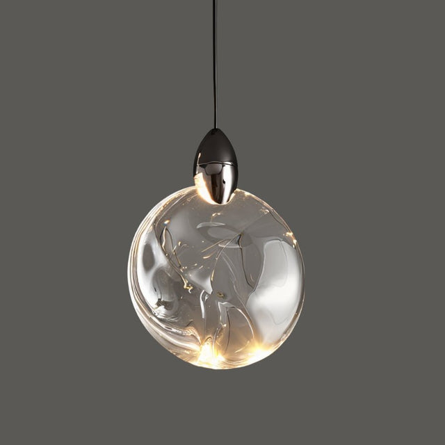 "A round, crystal pendant light with a metallic cap hangs against a grey background, showcasing its modern design."