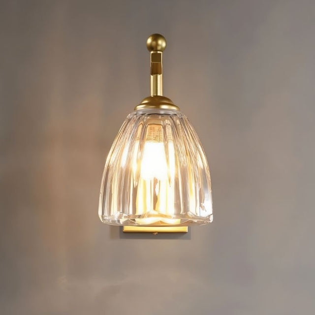 "A gold wall lamp with a fluted glass shade."