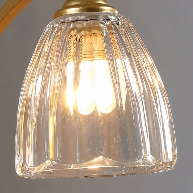 "A close-up detail of the gold wall lamp's fluted glass shade."