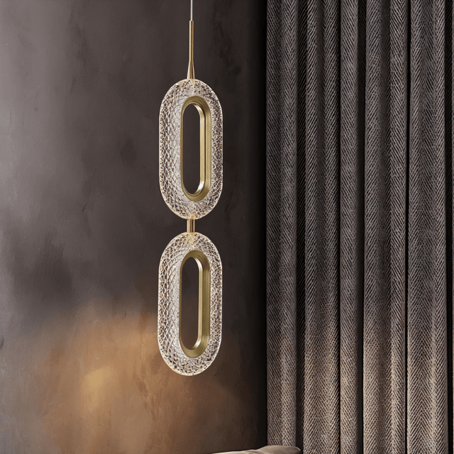 Contemporary Luxin Pendant Light with dual oval LED elements in copper and acrylic, illuminating a dark modern interior.