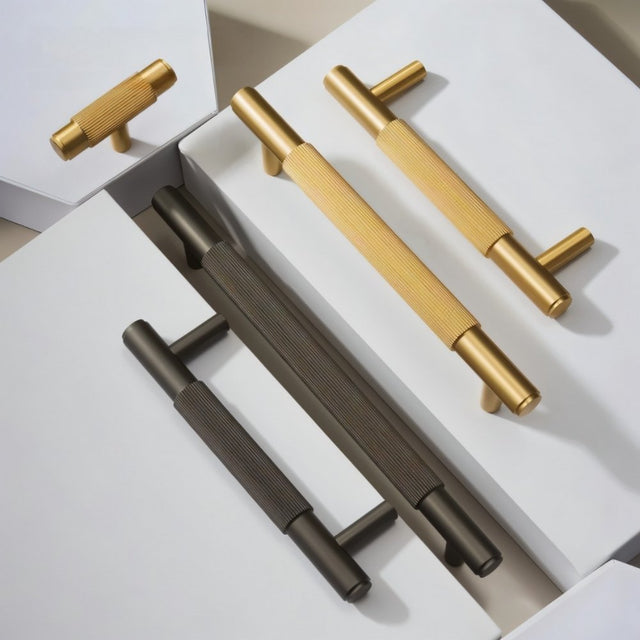 "Modern brass cabinet knobs and pull handles with a textured, knurled grip in gold and gray finishes."