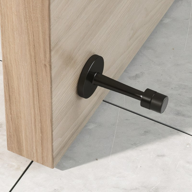 "Sleek, cylindrical zinc-alloy door stop with extended arm, wall-mounted to prevent a door from hitting the wall in a modern interior."