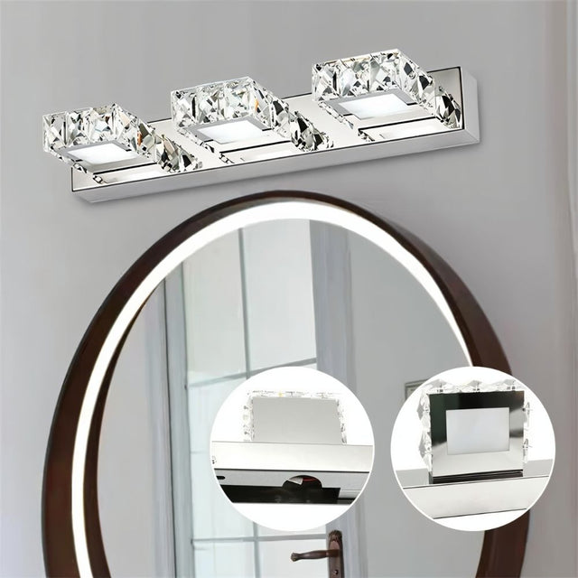 "A modern crystal wall light fixture mounted above an oval mirror in a bathroom, with close-up insets showcasing the crystal and metal detailing."