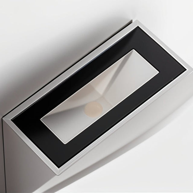 "Close-up view of a modern wall lamp with a black and silver finish, made from gypsum, featuring a minimalist design that casts soft light, perfect for contemporary interiors."