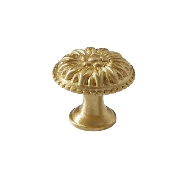 "Gold brass floral knob with raised petal detailing, isolated on a white background."