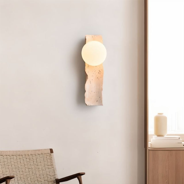"travertine wall lamp with frosted glass globe in a modern living space"