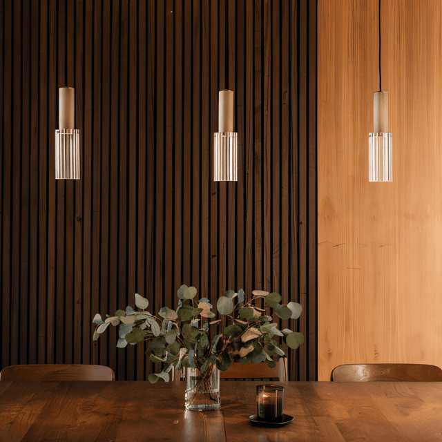 Nayra Copper Glass Pendant Lights installed above a wooden dining table with vertical wood paneling, creating a warm modern ambiance.