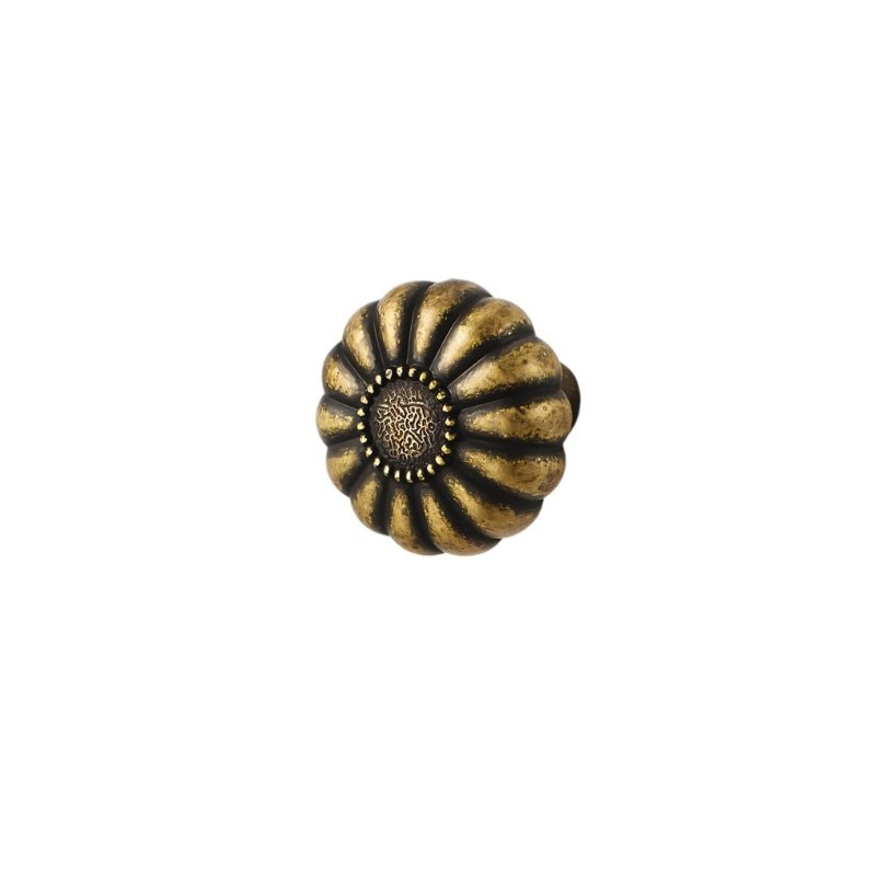 "A vintage brass flower-shaped knob with bold, rounded petals encircling a central medallion, featuring an intricate embossed pattern and a ring of raised dots, isolated on a white background."