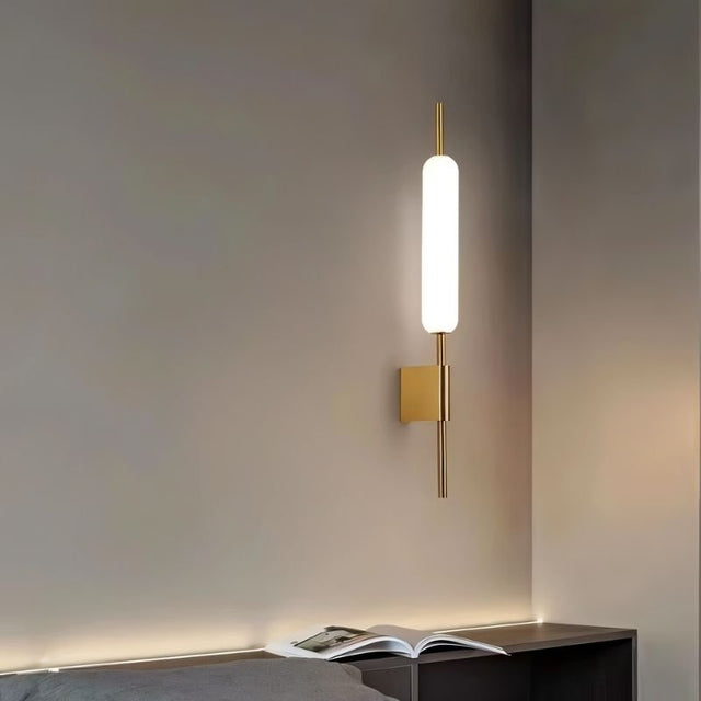 "Modern wall lamp with a cylindrical glass diffuser and iron frame used as a bedside sconce."