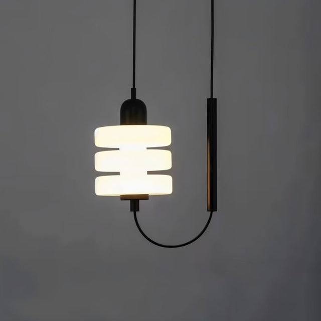 "Close-up of a modern pendant light with a layered frosted glass diffuser and black iron frame."