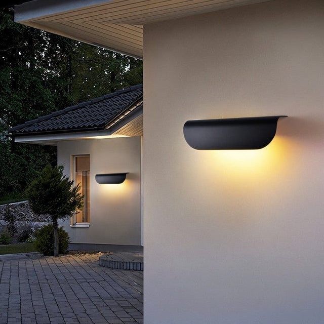 "Modern outdoor wall lamp with a minimalist half-cylinder design made of durable aluminum, emitting a soft, diffused glow, enhancing outdoor aesthetics."