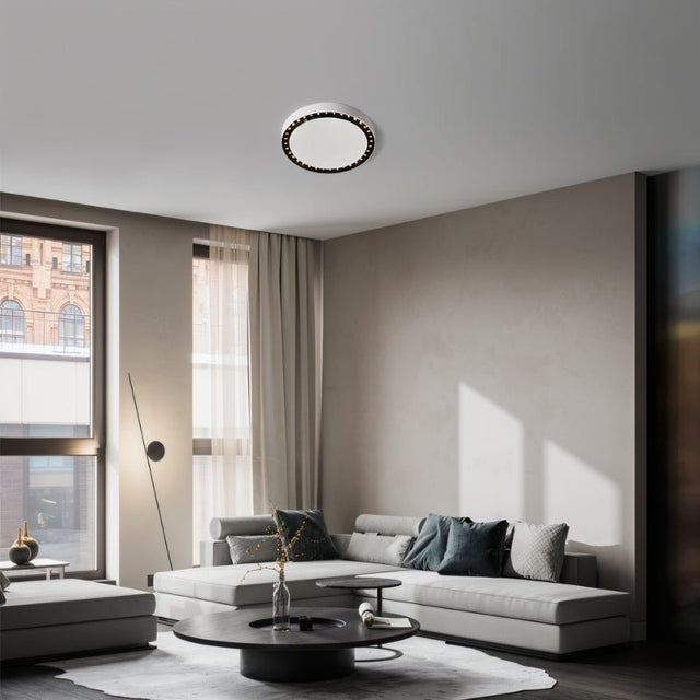 "The Nival ceiling light provides sophisticated lighting in a modern living room, made from durable acrylic and aluminum, enhancing the space with its elegant circular design."