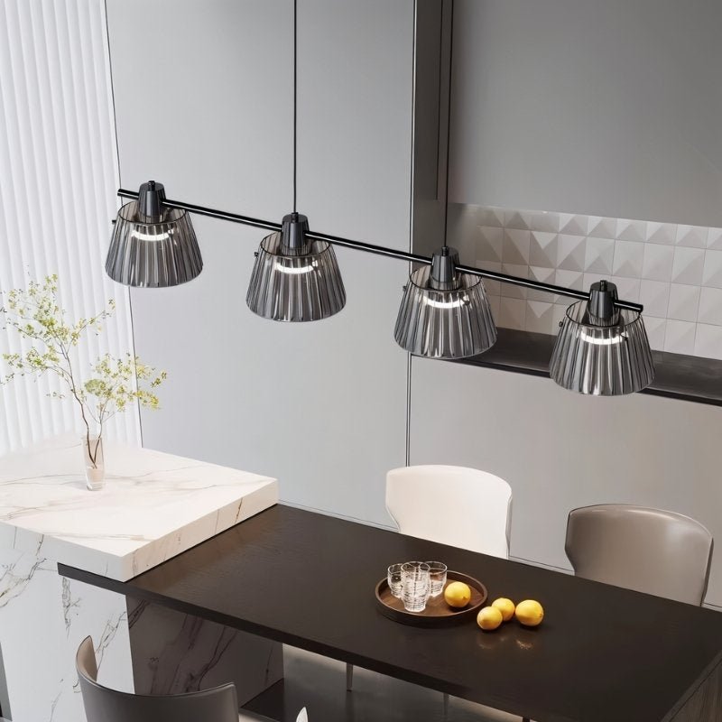 "Modern linear chandelier with ribbed glass shades and a black iron frame illuminating a contemporary kitchen."