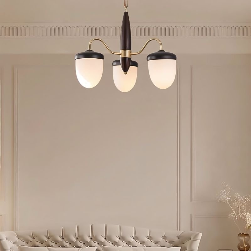 "A 3-light chandelier with brass arms, wooden centerpiece, and frosted glass shades in a living room interior."