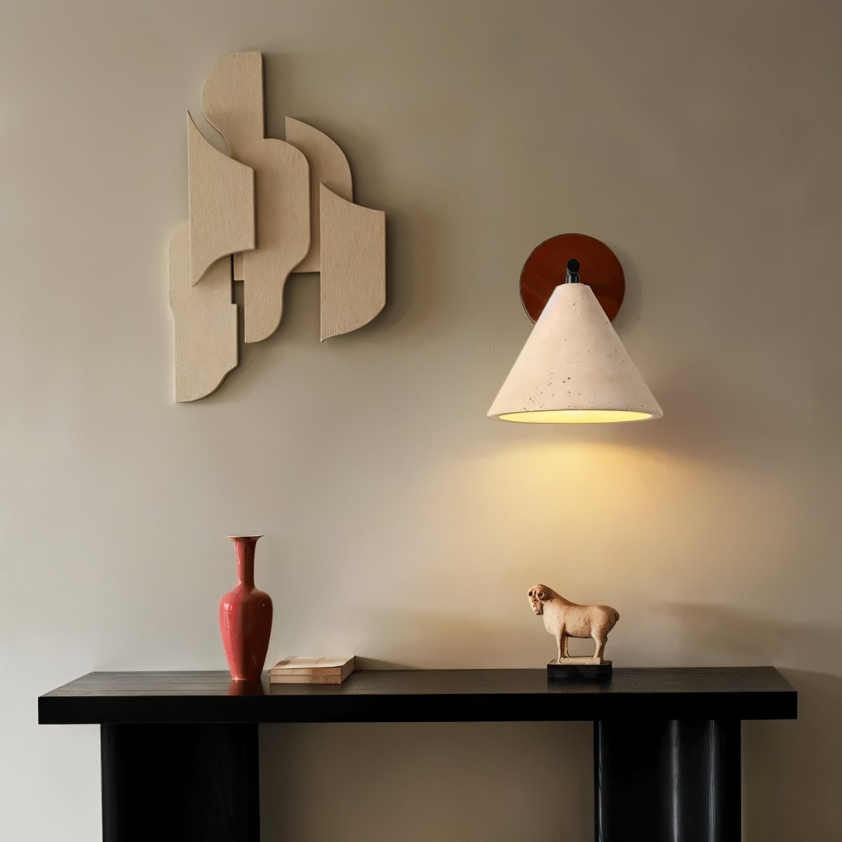 "A modern wall lamp with a conical travertine shade and a black arm, mounted on a wooden backplate in a living room, casting a soft, warm glow."